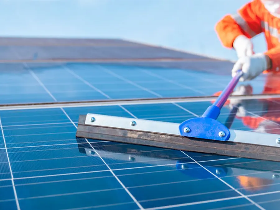 Técnico realizando limpeza de módulos fotovoltaicos